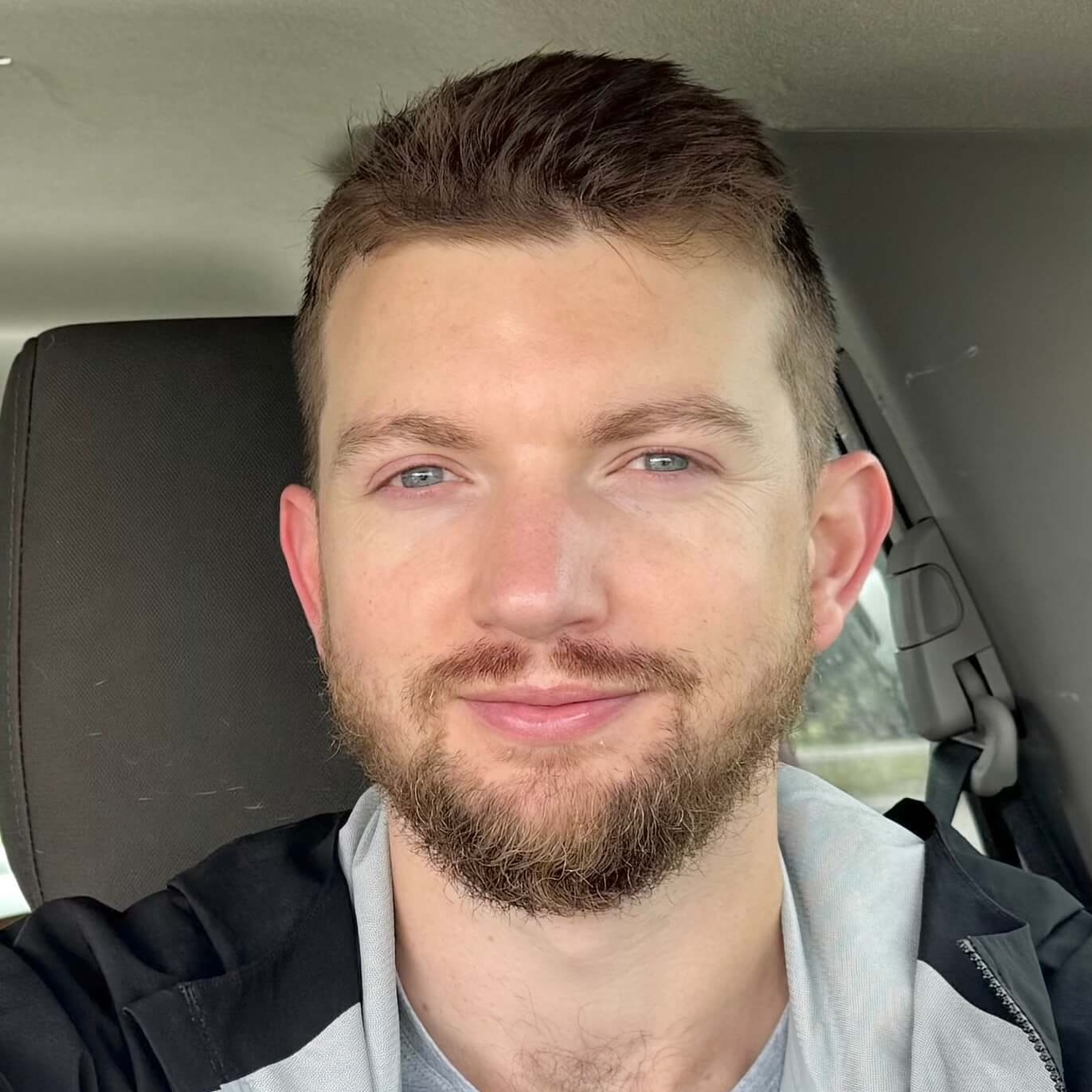A picture of Ryan Token sitting in the back of a car.